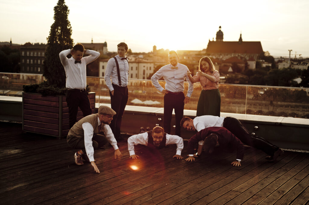 członkowie zespołu Lazy Swing Band stojący na dachu w tle zachodzacego słońca